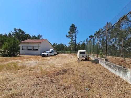 deux voitures garées dans un champ à côté d'un bâtiment dans l'établissement Casas Chris Cavadas, 