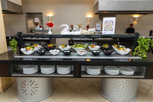 a buffet with plates and bowls of food on a counter at Le Petit Palais Djerba & Spa in Houmt Souk