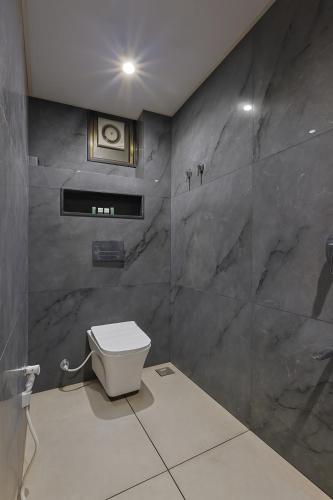 a bathroom with a white toilet in a room at The Sky Imperial Welcome, Somnath in Somnath
