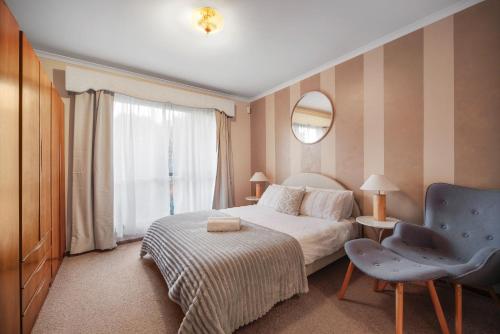 a hotel room with a bed and a chair at Peaceful Garden location in Hoppers Crossing in Tarneit