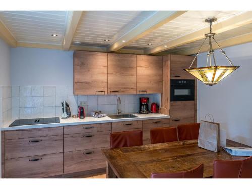 a kitchen with a wooden table and a light fixture at Farmhouse Lodge in Texel near the Dyke in Oost