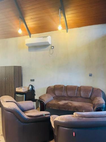 a living room with brown leather furniture and a couch at Fair View Cottage in Ella