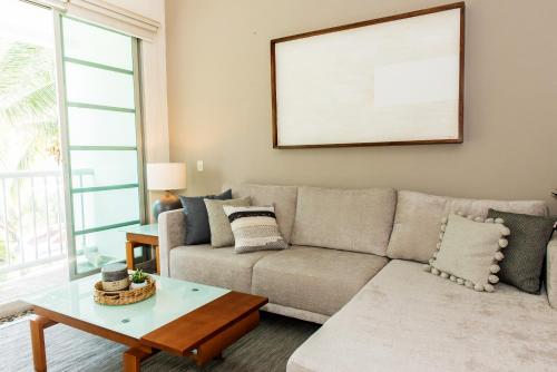 a living room with a couch and a table at Departamento Mayan Lakes T11 - Albercas, club de playa, tenis, pádel y más in Acapulco