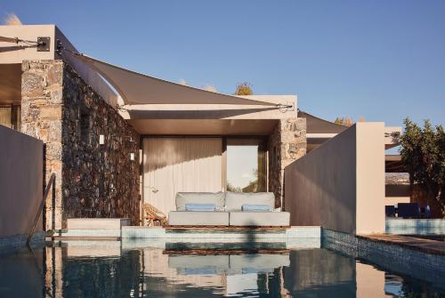 a house with a swimming pool next to a house at St. Nicolas Bay Resort Hotel & Villas in Agios Nikolaos