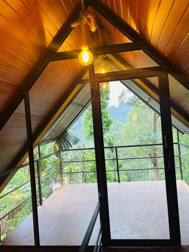 a room in a tree house with a large window at Fair View Cottage in Ella
