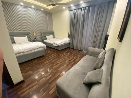 a living room with two beds and a couch at Elysium Prestige Pent House City View Islamabad in Islamabad