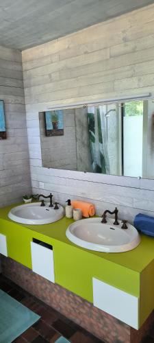 a bathroom with two sinks and a mirror at le refuge des étangs in Vignoux-sur-Barangeon