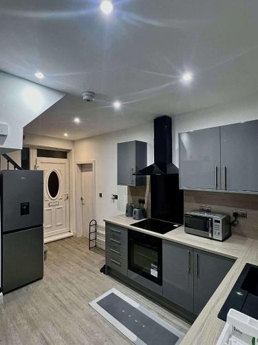 a kitchen with stainless steel appliances in a room at Luxeliving The Larch Residence in High Hazels