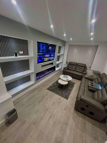 a living room with a couch and a tv at Luxeliving The Larch Residence in High Hazels