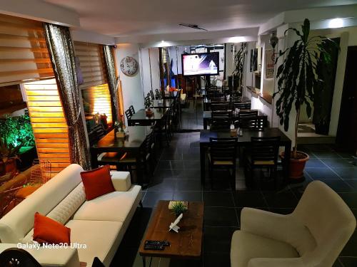 a restaurant with a couch and tables and a bar at Paperon Butik Otel in Limonlu