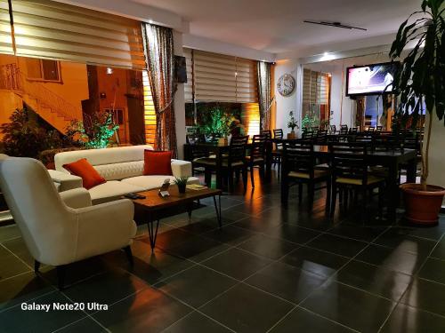 a restaurant with a couch and tables and chairs at Paperon Butik Otel in Limonlu
