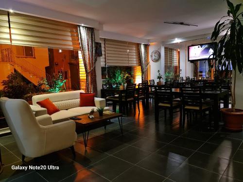 a living room with a couch and tables and a bar at Paperon Butik Otel in Limonlu