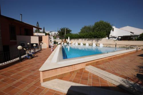 una piscina en medio de un patio de ladrillo en La Casa di Marta, en San Leone