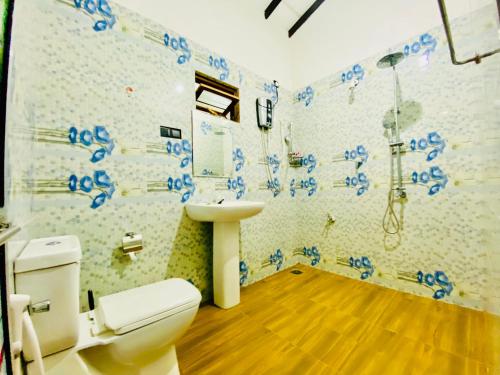 a bathroom with a toilet and a sink and a shower at Priyavimana resort in Habarana