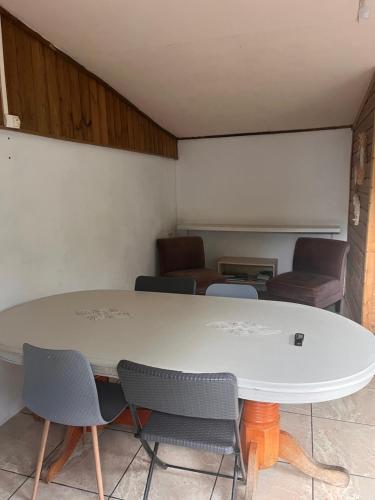 a white table and chairs in a room at LaKour Fleurie Chambres d hôtes in Sainte-Rose