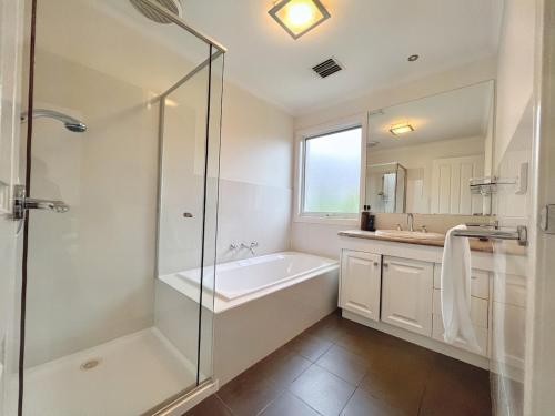 a bathroom with a shower and a tub and a sink at No 58 Bright & Spacious 4-Bedroom Home in Doncaster