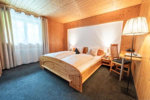 a bedroom with a large bed with a desk and a window at Hotel Gasthaus Schäfle in Bürserberg