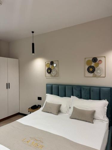 a bedroom with a large white bed with two pillows at Villa La Mer Durres in Durrës