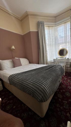 a bedroom with a large bed in front of a window at Bronte House - Blackpool in Blackpool