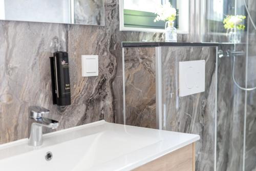 un bagno con un lavandino e un telefono a parete di Mobile Homes Holland - Jersleber See Camping & Erlebnisresort a Jersleben