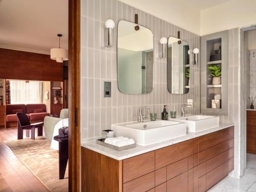 a bathroom with two sinks and a living room at Sir Devonshire Square Hotel, part of Sircle Collection in London