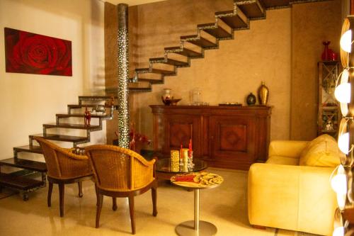 ein Wohnzimmer mit einer Treppe und einem Tisch und Stühlen in der Unterkunft Agata 1913 in Galatina
