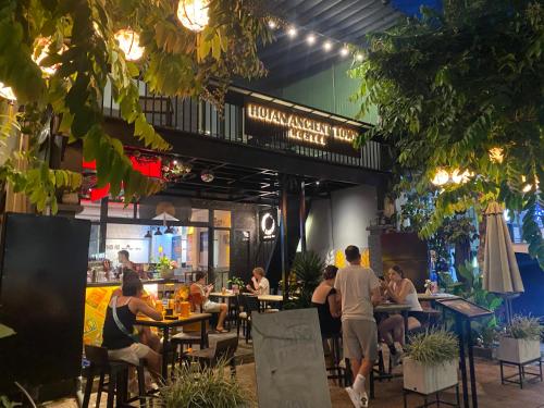 a group of people sitting at tables in a restaurant at Hoi An Ancient Town Hostel & Bar in Hoi An