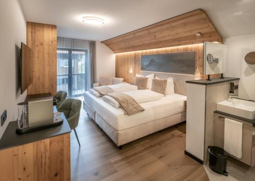 a bedroom with a bed and a desk with a laptop at Mäsers Allgäuherz in Wiggensbach