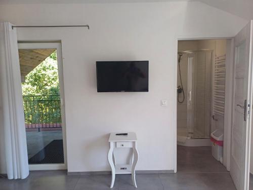 a white room with a table and a tv on a wall at Gościniec Solan in Jeleniów