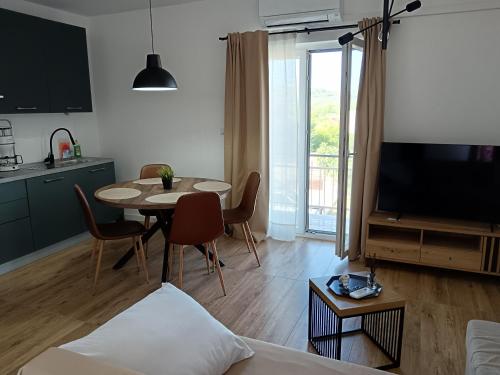 a living room with a table and a dining room at Apartman PAVLA in Betina