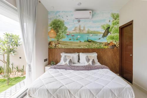 a bedroom with a bed with a painting on the wall at The Garden Stay by StayJadePool2BHKLawnAC in Berikai