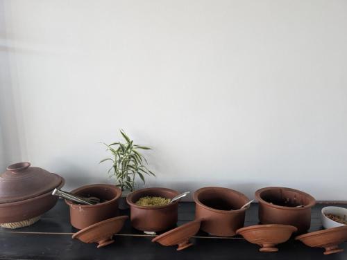 a group of pots sitting on a table with a plant at White Lotus Haputale in Haputale
