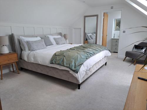 a bedroom with a large bed and a mirror at Nanny lane loft in Church Fenton