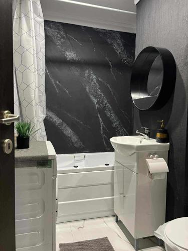 a bathroom with a white tub and a sink and a bath tubermott at holiday apart in Oradea