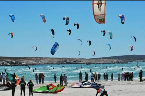 un gruppo di persone su una spiaggia che volano aquiloni di West Coast Retreat a Saldanha