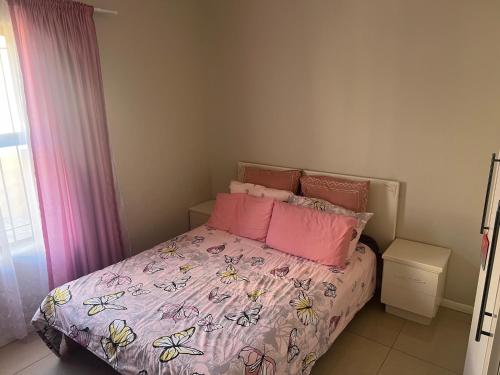 una camera da letto con letto e cuscini rosa di West Coast Retreat a Saldanha