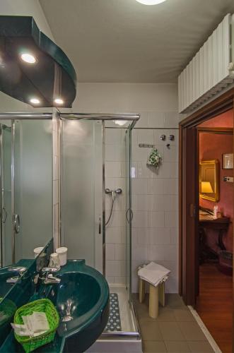 a bathroom with a green tub and a shower at Hotel Rex in Lucca