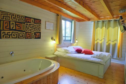 una camera con vasca e un letto di Ein Zivan Village Resort a Ein Zivan