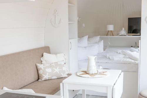 a white living room with a couch and a table at Iglus 4 Personen - Jersleber See Camping & Erlebnisresort in Jersleben