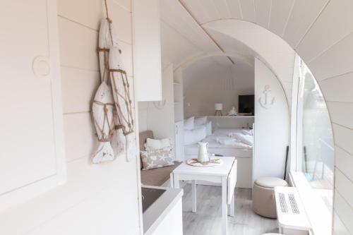 a white room with a bed and a table at Iglus 4 Personen - Jersleber See Camping & Erlebnisresort in Jersleben