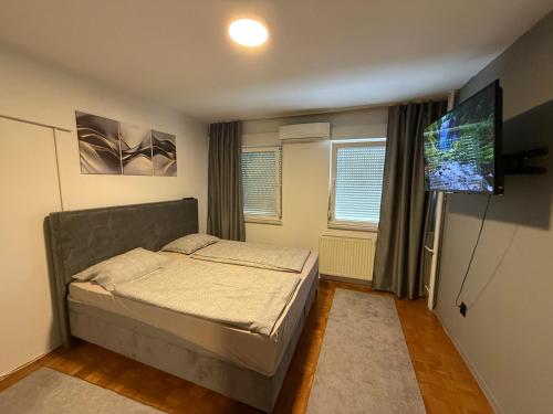 a bedroom with a bed and a flat screen tv at Luxury Apartment Tuzla in Tuzla
