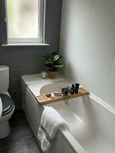 a bathroom with a bathtub with a plant on it at Wallasey Home - 2 Min to Liverpool Ferry Seacombe, Beach & Free Parking in Wallasey