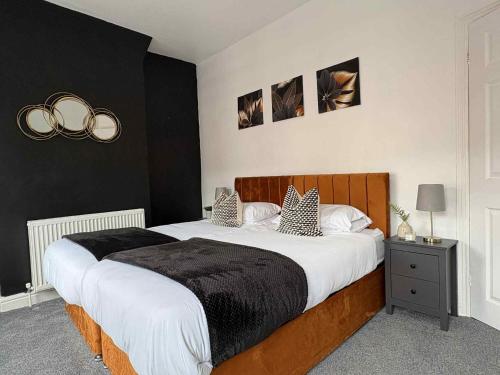 a bedroom with a large bed with black and white at Wallasey Home - 2 Min to Liverpool Ferry Seacombe, Beach & Free Parking in Wallasey