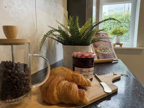 a table with a loaf of bread on a cutting board at Wallasey Home - 2 Min to Liverpool Ferry Seacombe, Beach & Free Parking in Wallasey