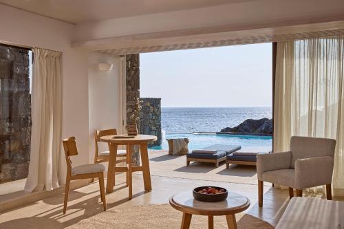 a living room with a view of the ocean at St. Nicolas Bay Resort Hotel & Villas in Agios Nikolaos