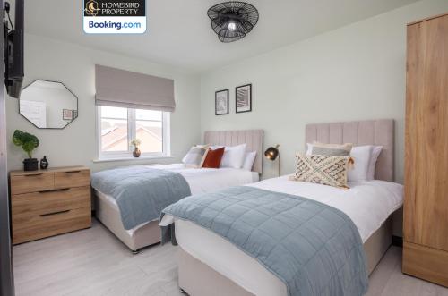 a bedroom with two beds and a dresser at Luxuriou 5 Bedroom House By Homebird Property Management Short Lets & Serviced Accommodation Leeds With Private Parking & Free WiFi in Leeds