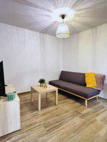 a living room with a couch and a table at Maison 2-5 pers au calme proche Parc in La Pommeraie-sur-Sèvre