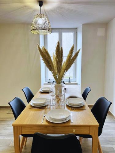 a wooden table with chairs and a potted plant at Maison 2-5 pers au calme proche Parc in La Pommeraie-sur-Sèvre