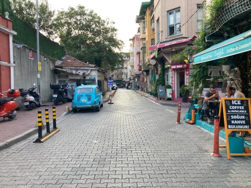 una piccola auto blu parcheggiata sul lato di una strada di Balat Butik Hotel a Istanbul