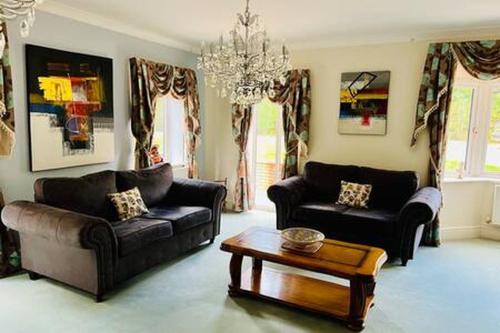a living room with two couches and a coffee table at Stratford 4 BR Family Mansion with Pool, Gym BBQ in Henley in Arden